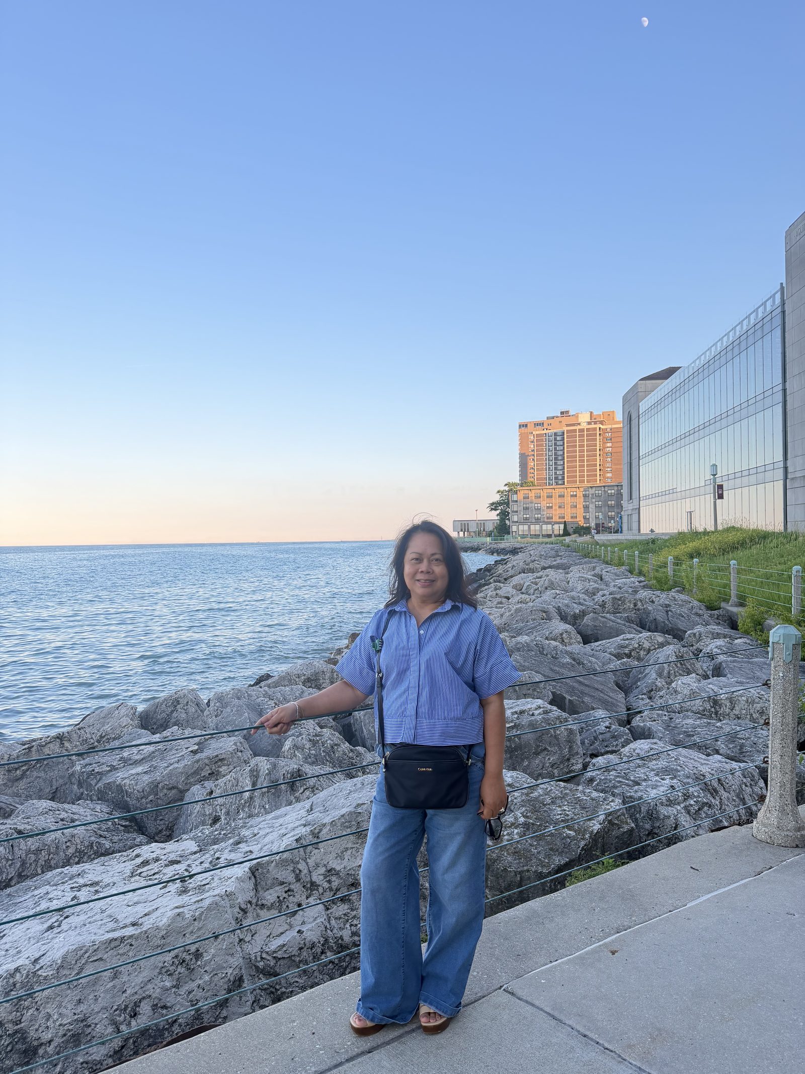 Genalyn seated on the lakefront rocks with the Chicago skyline behind her